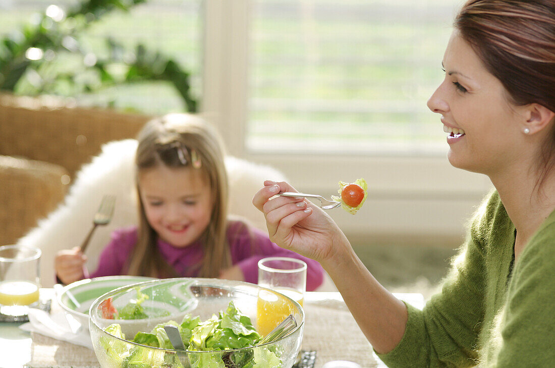 Young family eating salad, Munich, Germany