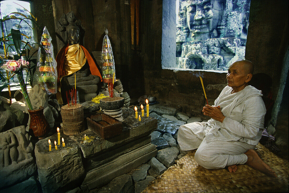Buddhist nun praying, Bayon temple, Angkor, Siem Raep, Cambodia,  Asia