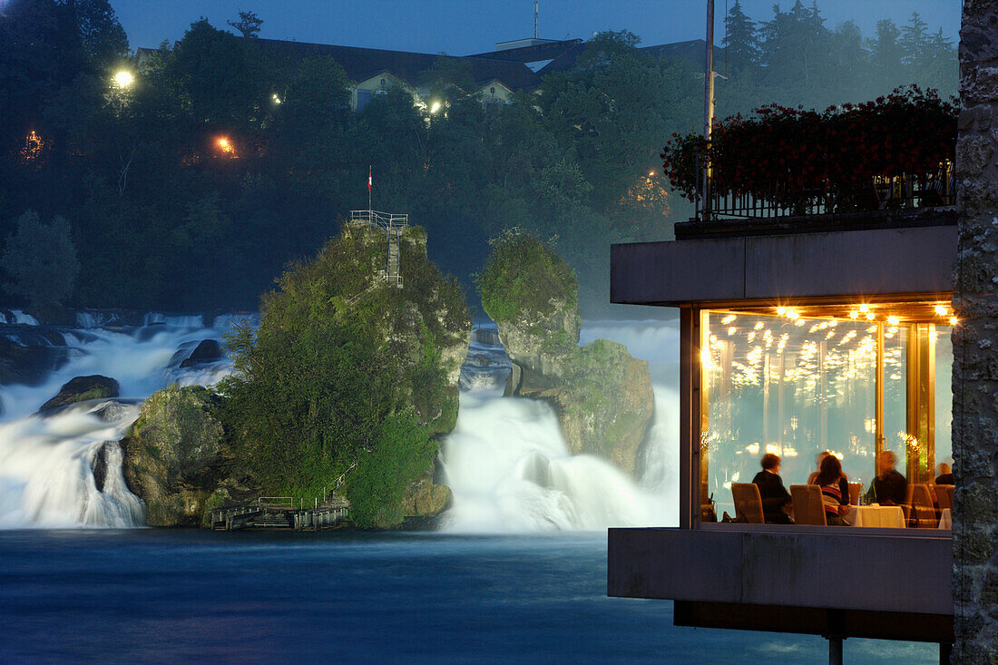 Rheinfall bei Nacht, Gäste im Park am Rheinfall Restaurant im Vordergrund, Neuhausen, Kanton Schaffhausen, Schweiz