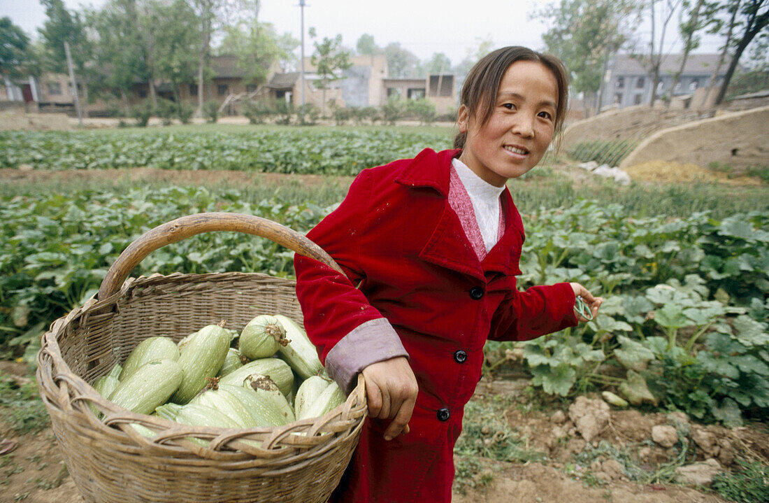 Woman with squash harvest Xinghe village. Shanxi Xian. China.