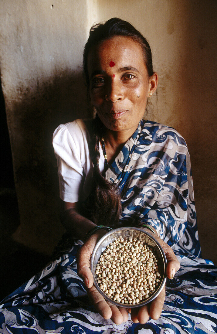 Padmanna, 30, a farmer, displaying traditional lentil seeds. Alaganahalli village, near Kolar, Karnataka. India.