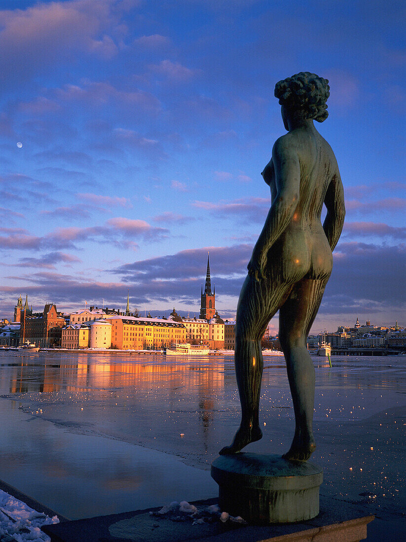 Riddarsholmen, winter view from city hall. Bronze statue of naked woman at fore. Stockholm. Sweden