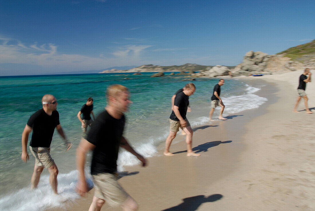 A group of men walking out of the sea, Adventure competition, North West coast, near Rena Majore, Sardegna, Sardinia, Italy, Europe, mr