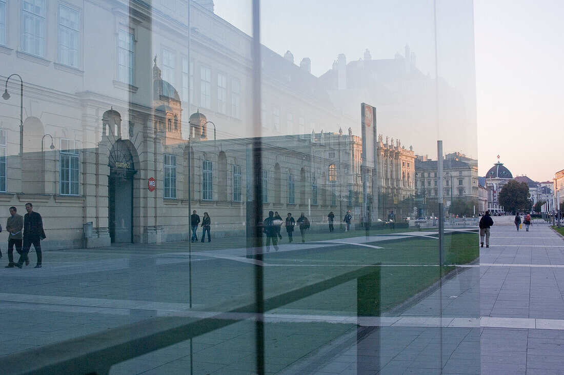Reflection of pedestrians and buildings on glass facade, Museumsquartier, Vienna, Austria
