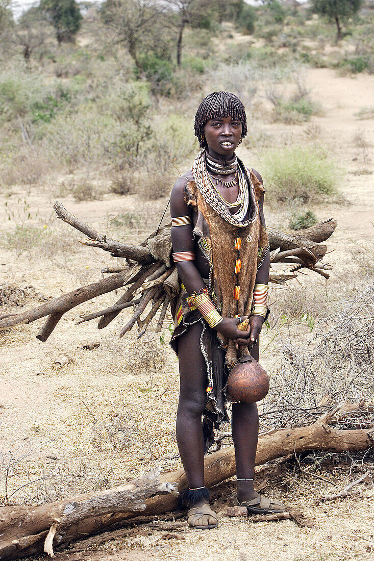 Woman Hamer tribe. Lower basin of Omo river. Copper skin with very fine features and wear metal arm and leg bracelets, shells and beads. South Ethiopia.