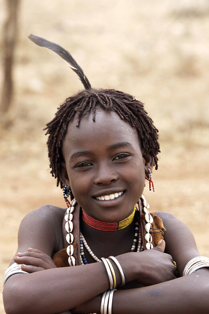 Girl Hamer tribe. Lower basin of Omo river. Copper skin with very fine features and wear metal arm and leg bracelets, shells and beads. Gamo Gofa region. South Ethiopia.