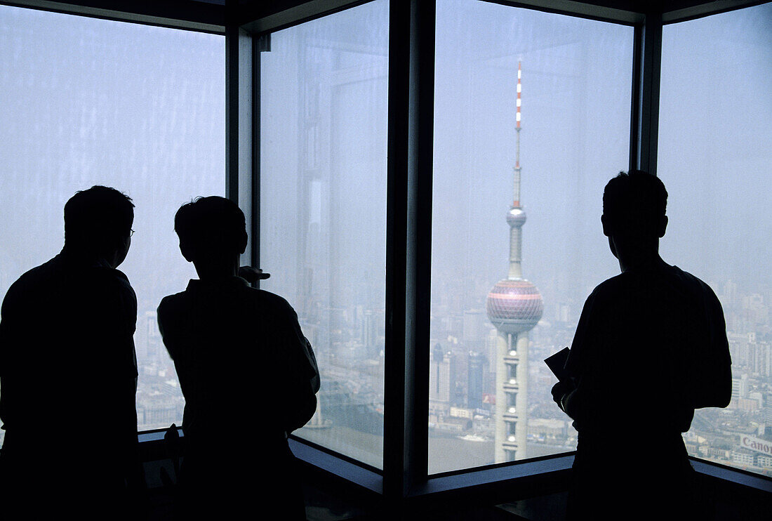 View from Jin Mao building observation deck in Pudong with Orient Pearl TV tower in foreground and Puxi area of city in background, Shanghai. China