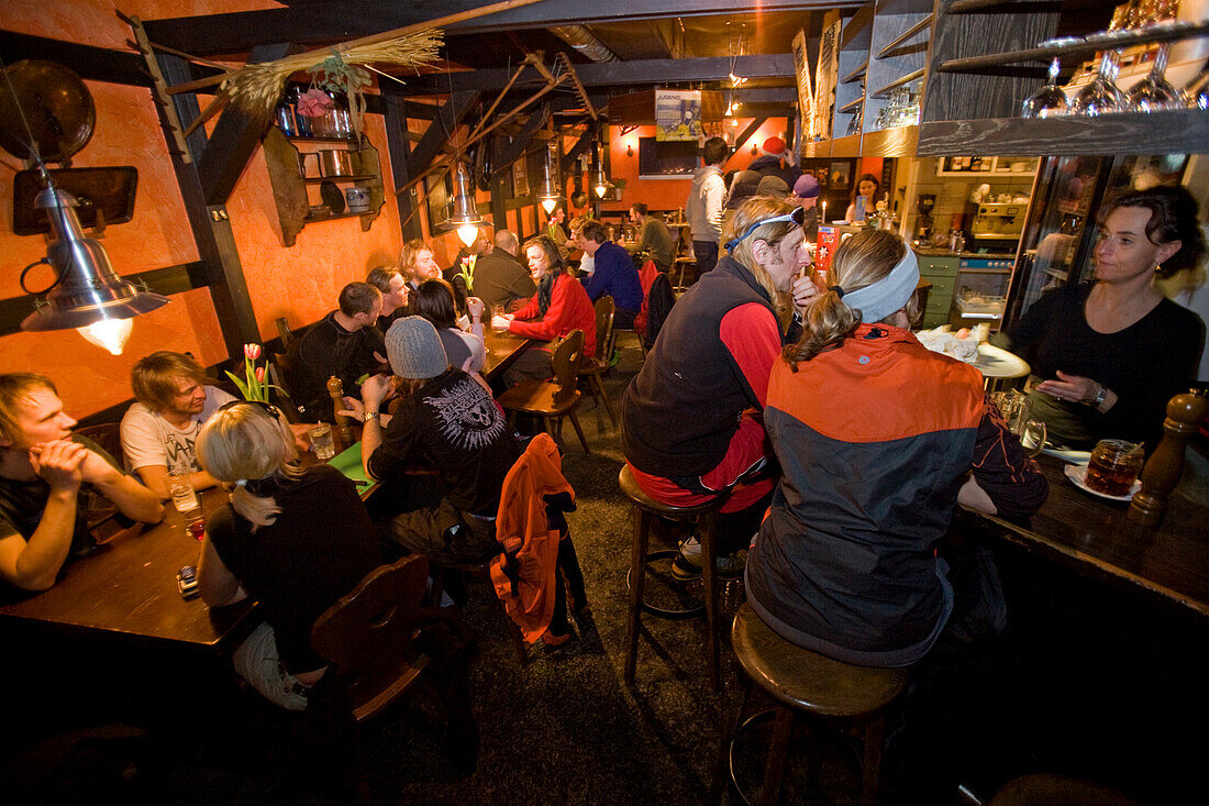 Skifahrer beim Apres Ski in einer Kneipe, Andermatt, Kanton Uri, Schweiz