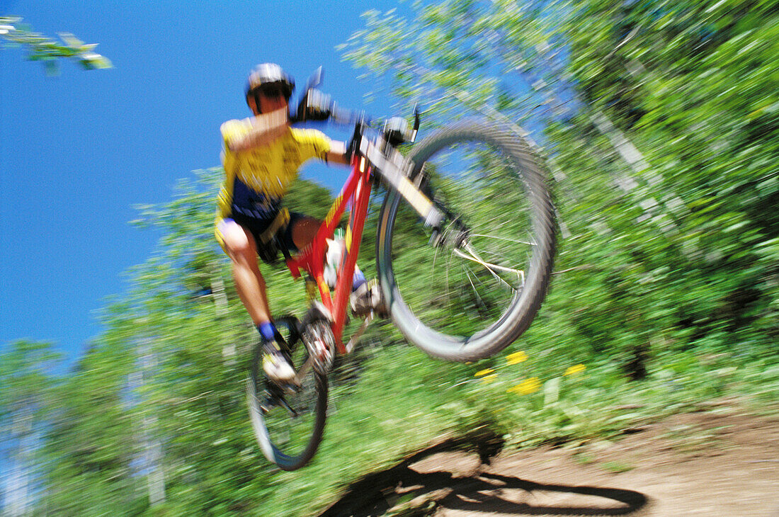 Mountain biker jumping in forest