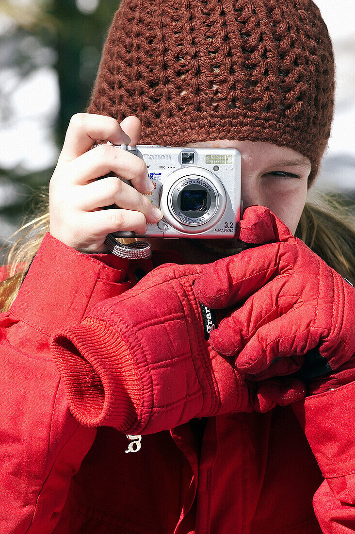 young girl in winter taking photos
