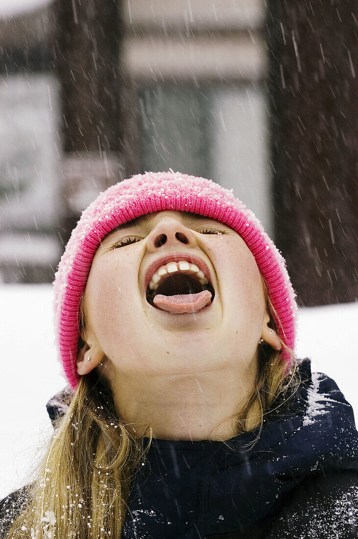 Girl catching snow in mouth
