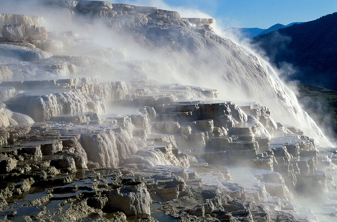 Steam on rocks and geyser Yellowstone NP, USA