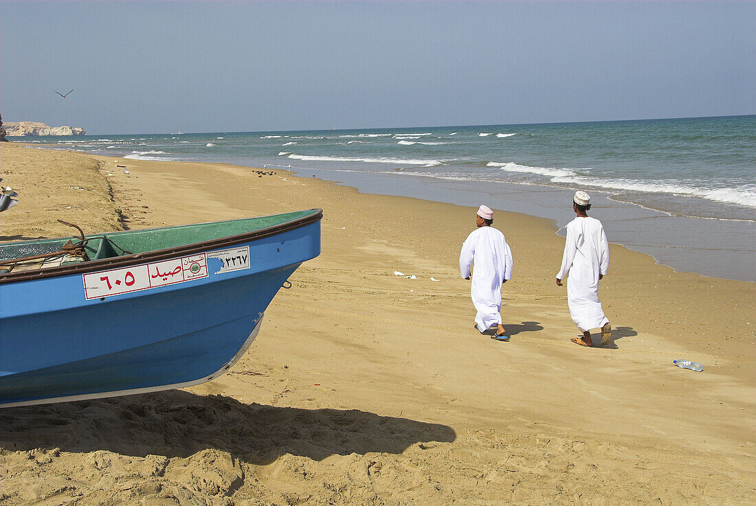Local Omani youths walking along the beach at Sifa, a popular recreational and fishing village near Muscat, Oman