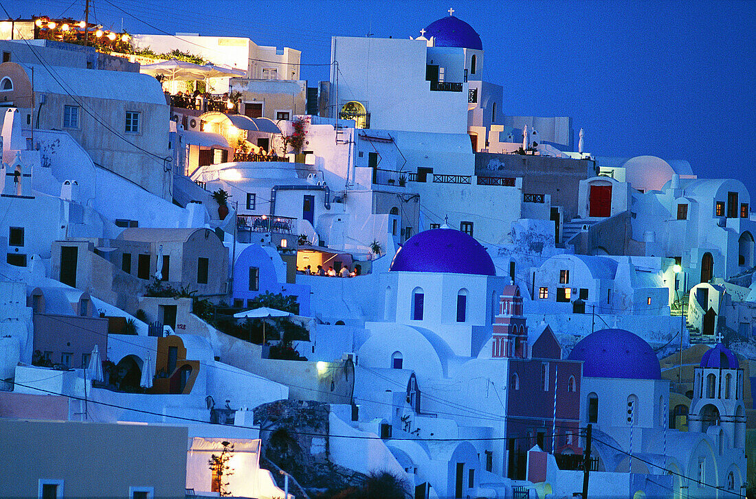 Greece, Cyclades, Santorini , White houses and blue dome church on sunset over caldeira at Oia.
