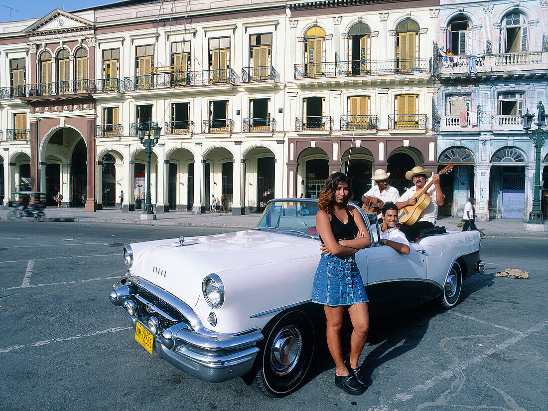 Cuba, Havana, Capitol place. Young friends playing music. Old American car