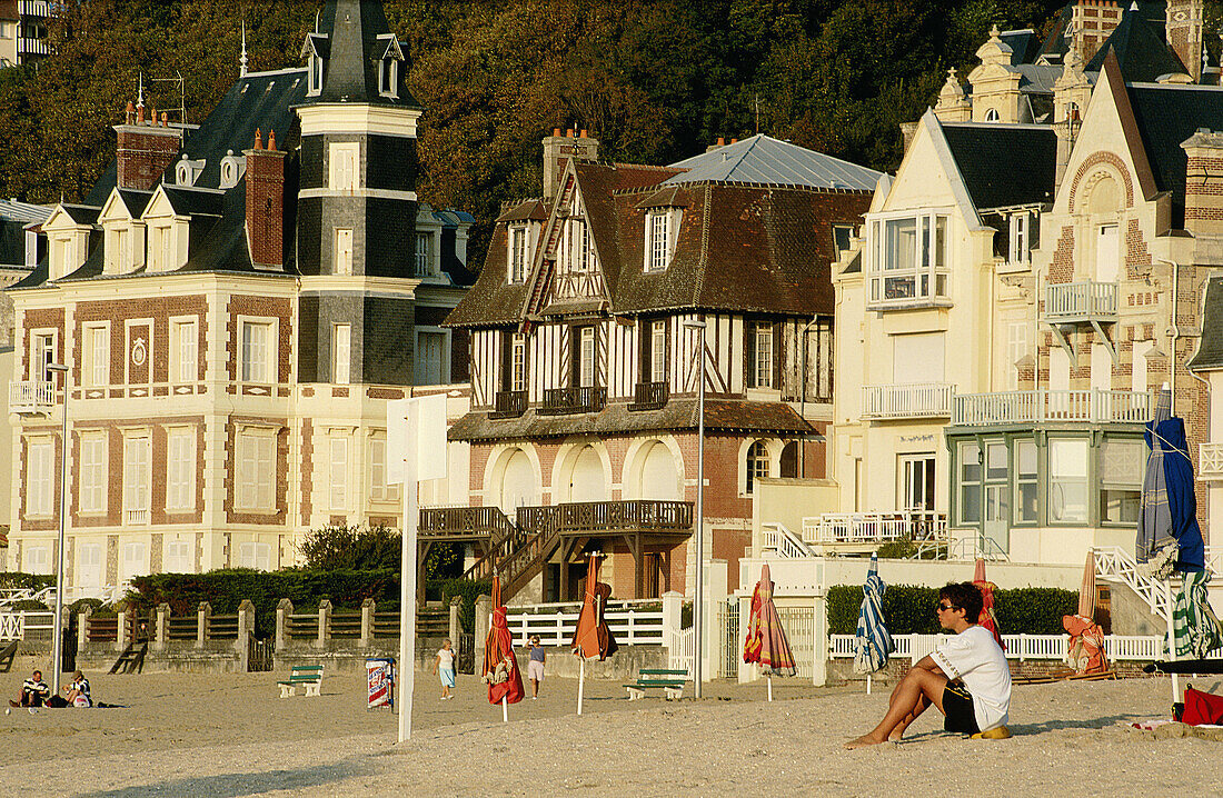 France, Normandy, Bathing Station, Deauville-Trouville, Parasols, path called les Planches kind having a rest by the beach