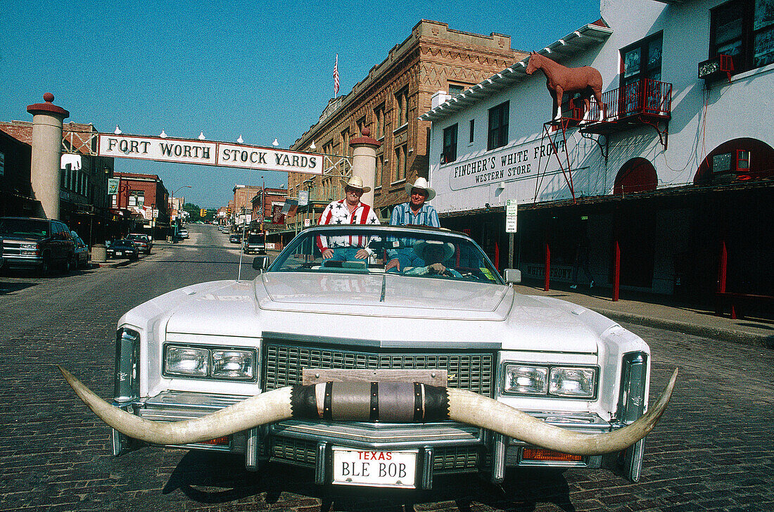 Cowboys driving convertible car at Stockyards, Fort Worth. Texas, USA