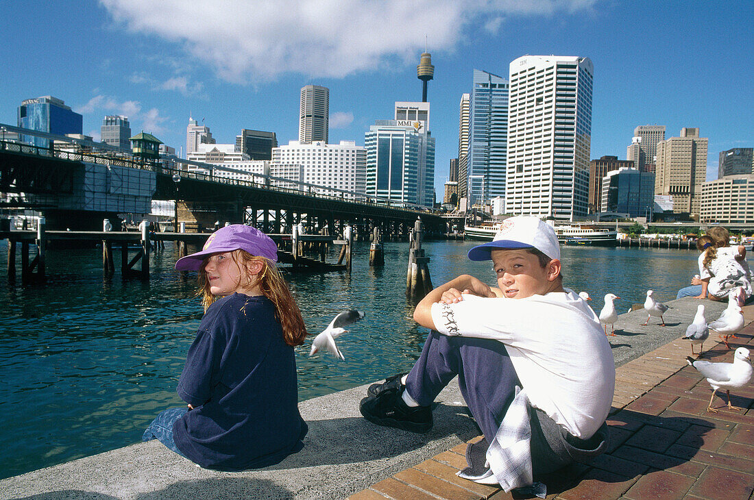 Kids having a rest. Darling Harbour. Business district. Downtown. Sydney. Australia.