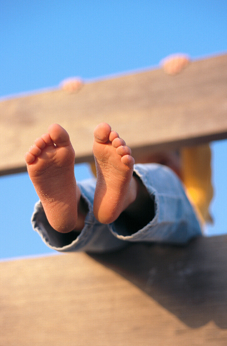 Young girl s feet through a fence