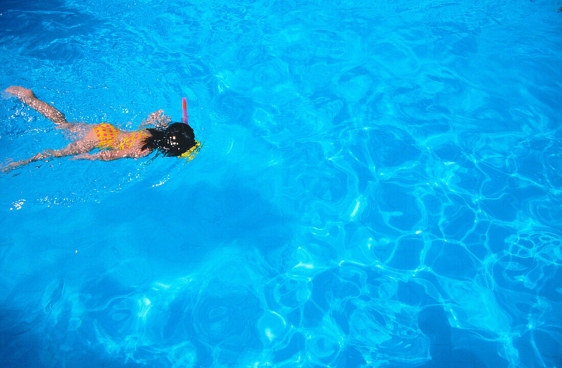 Child snorkeling in pool