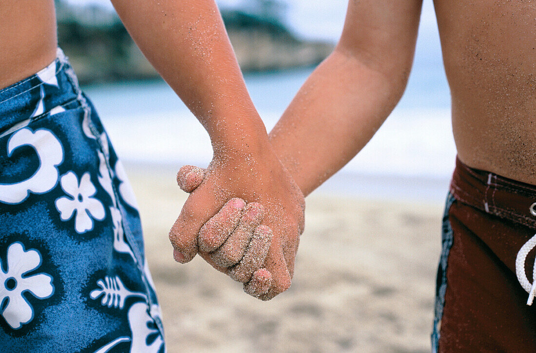 Friends holding hands at beach