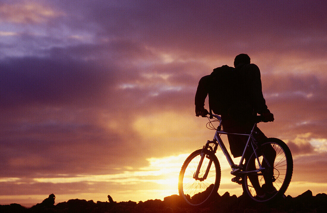 Biker betrachtet einen Sonnenuntergang