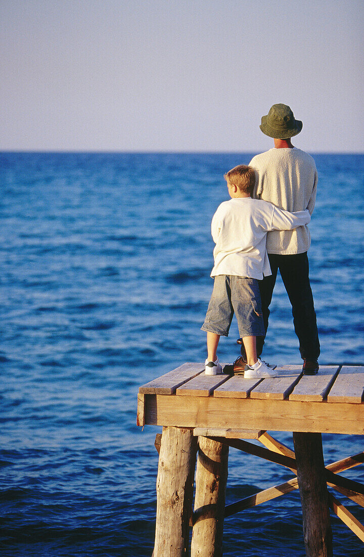 ian, Caucasians, Child, Children, Color, Colour, Contemporary, Dad, Daytime, Dock, Docks, Embrace, Embracing, Exterior, Families, Family, Father, Fathers, Full-body, Full-length, Hat, Hats, Headgear