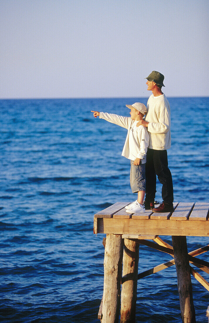 ians, Child, Children, Color, Colour, Contemporary, Dad, Daytime, Dock, Docks, Embrace, Embracing, Exterior, Families, Family, Father, Fathers, Full-body, Full-length, Hat, Hats, Headgear, Horizon, Ho