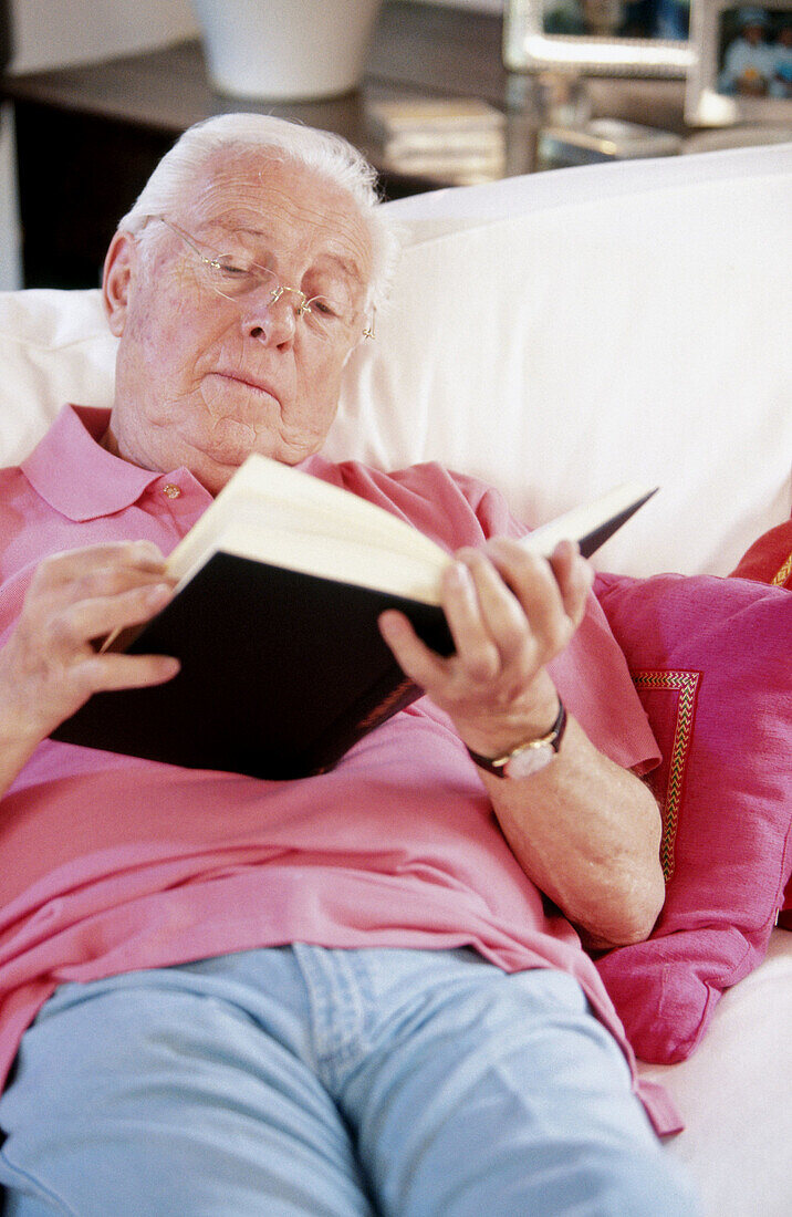 s, At home, Book, Books, Caucasian, Caucasians, Chill out, Chilling out, Color, Colour, Contemporary, Couch, Couches, Eyeglasses, Glasses, Gray-haired, Grey-haired, Home, Human, Indoor, Indoors, Insid