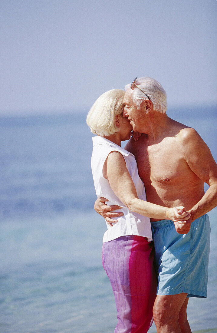 each, Beaches, Bond, Bonding, Bonds, Caucasian, Caucasians, Color, Colour, Contemporary, Couple, Couples, Daytime, Embrace, Embracing, Exterior, Female, Fondness, Gray-haired, Grey-haired, Grin, Grinn