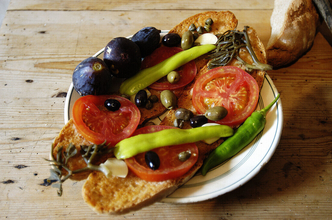 Traditional Majorcan meal, bread with oil and tomatoes, olives, figs, fennel and green peppers