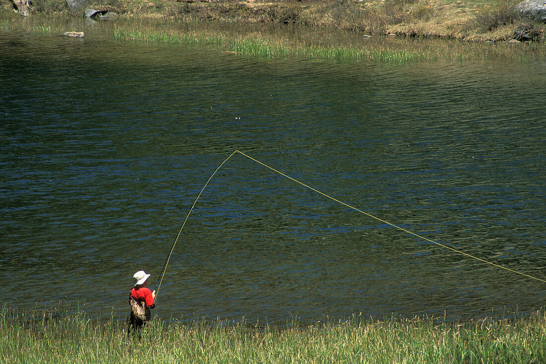 Young male boy fly fishing in alpine Mack Lake, Little Lakes Valley, Rock Creek, Inyo NF, Eastern Sierra, California