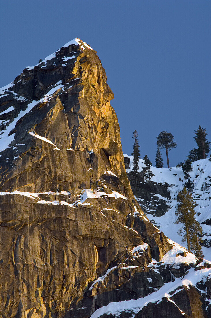 Golden Sunset light on granite rock mountain peak above Yosemite Valley, Yosemite National Park, California
