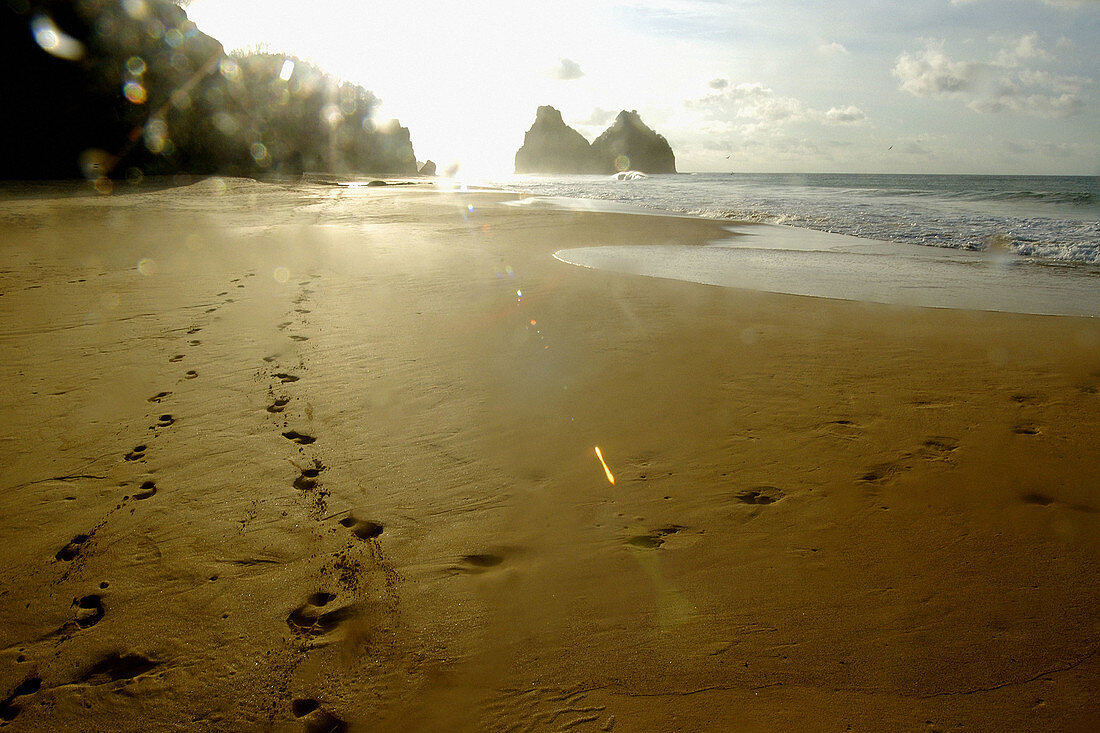 Footprints in Cacimba do Padre beach and Dois Irmãos islands in background, Fernando de Noronha national marine sanctuary. Pernambuco state, Brazil