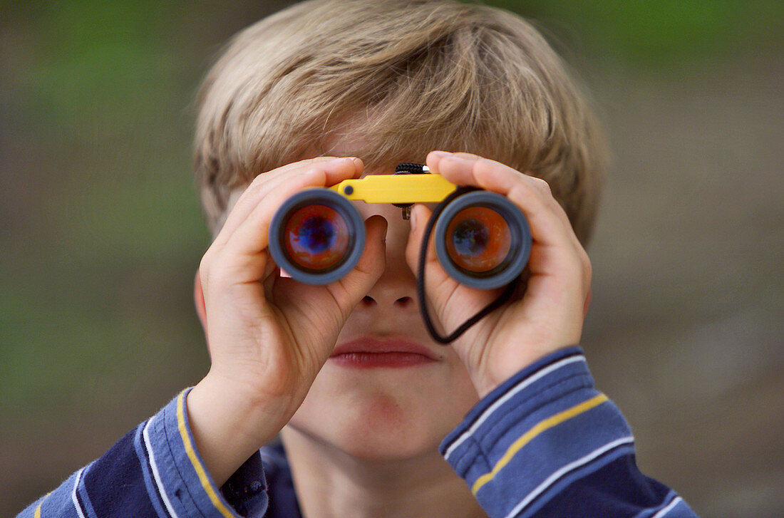 Boy, 8 years old, looking through binoculars.