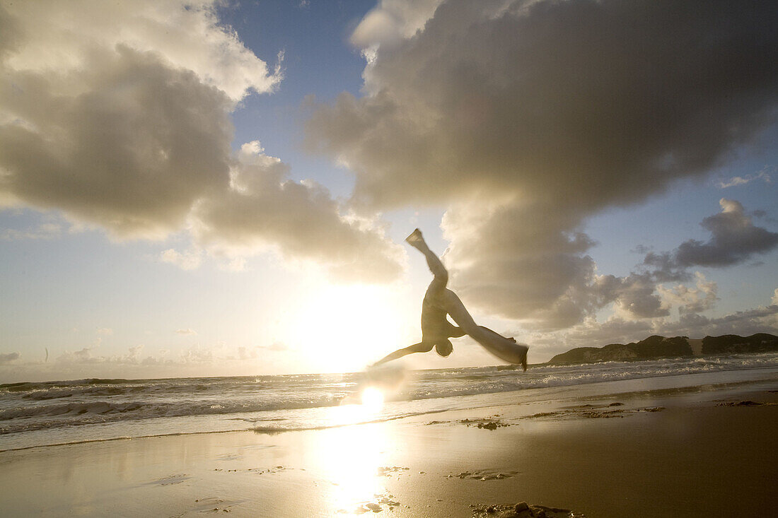 Capoeira player training and exercising in the beach, Brazil.
