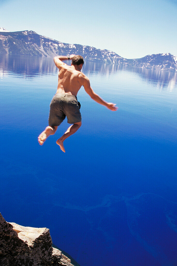 Man jumping into Crater Lake. Oregon. USA