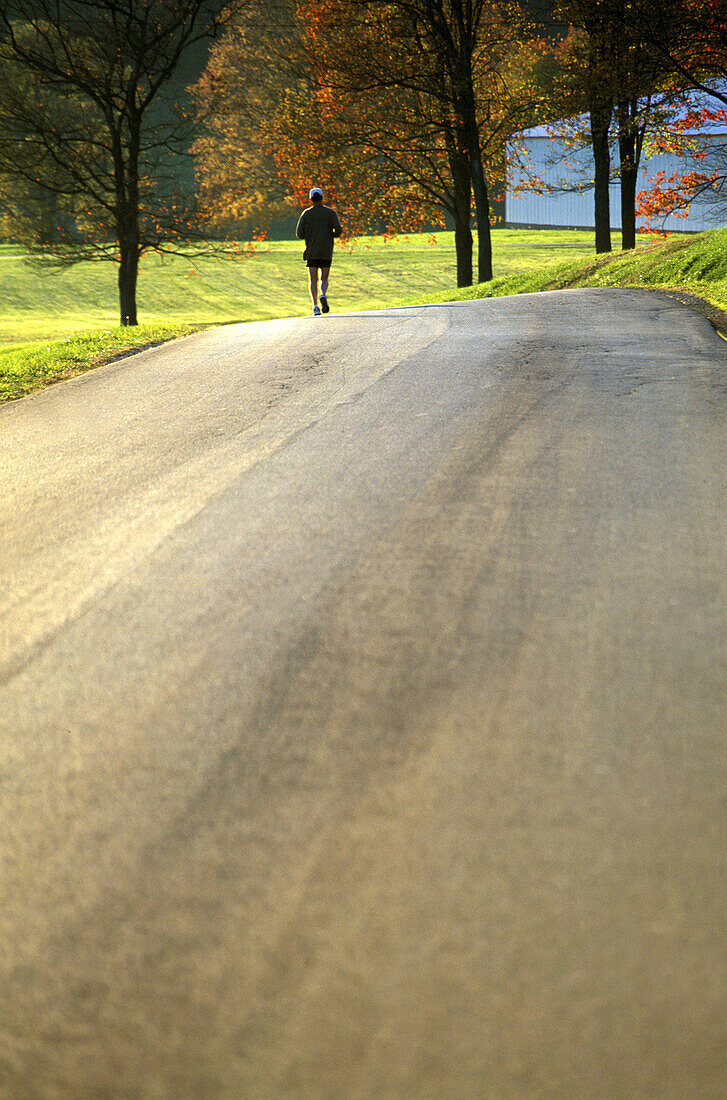 Jogger exercises on Pennsylvania country road, USA.