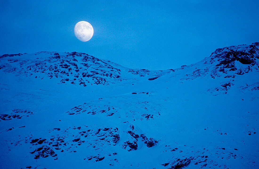 Moonrise over a snowy mountain. Bardu. Norway
