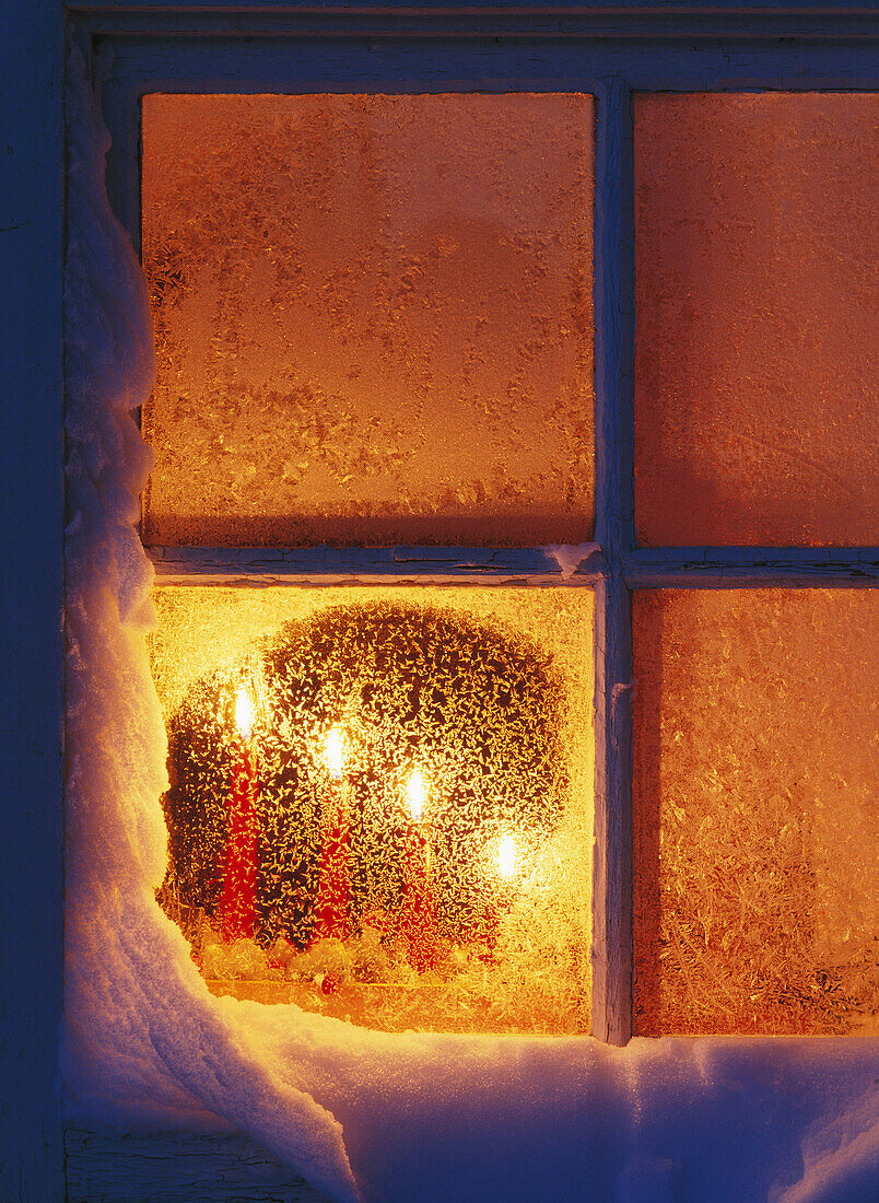 Candles in a frosty window