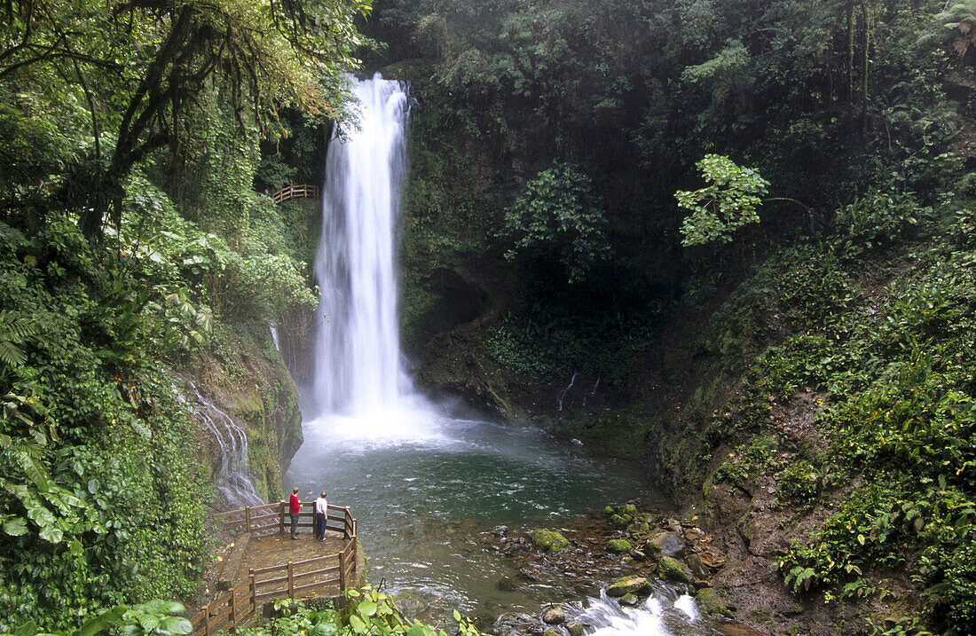 Two persons in front of La Paz waterfall. Costa Rica.