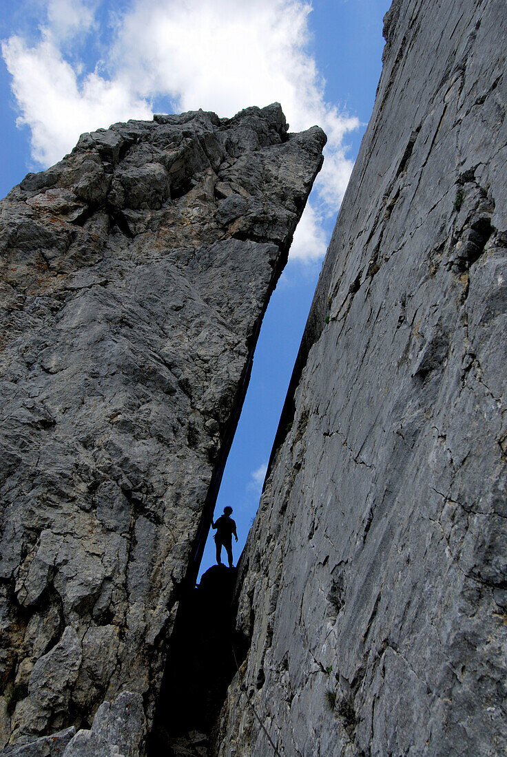 Silhouette of person in a crevice, mount Kopftoerl, Kaiser range, Tyrol, Austria