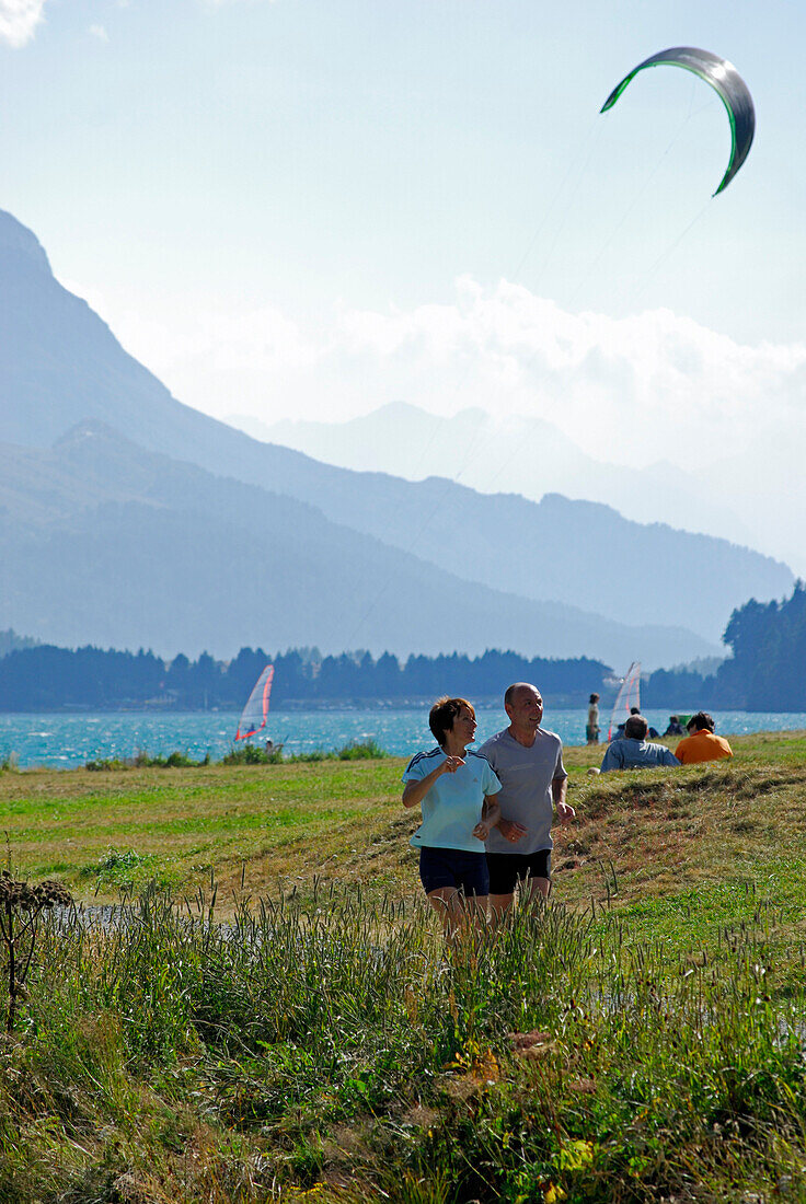runner and kite-surfer at lake Silvaplaner See, Lej da Silvaplauna, Engadin, Grisons, Switzerland