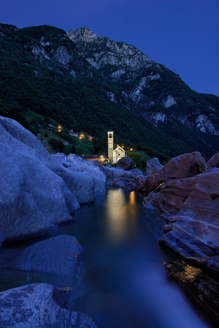Verzasca in der Dämmerung mit beleuchteter Kirche von Lavertezzo, Tessin, Schweiz