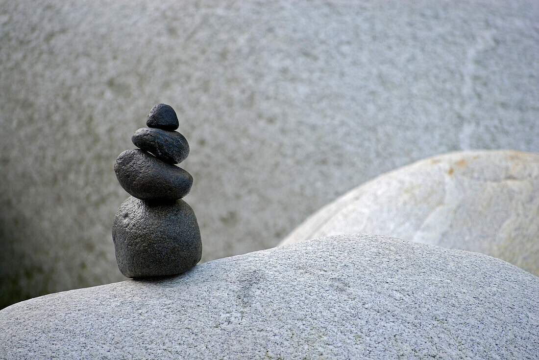 Cairn from black pebbles on white rock, valley of Verzasca, Verzasca, Ticino, Switzerland