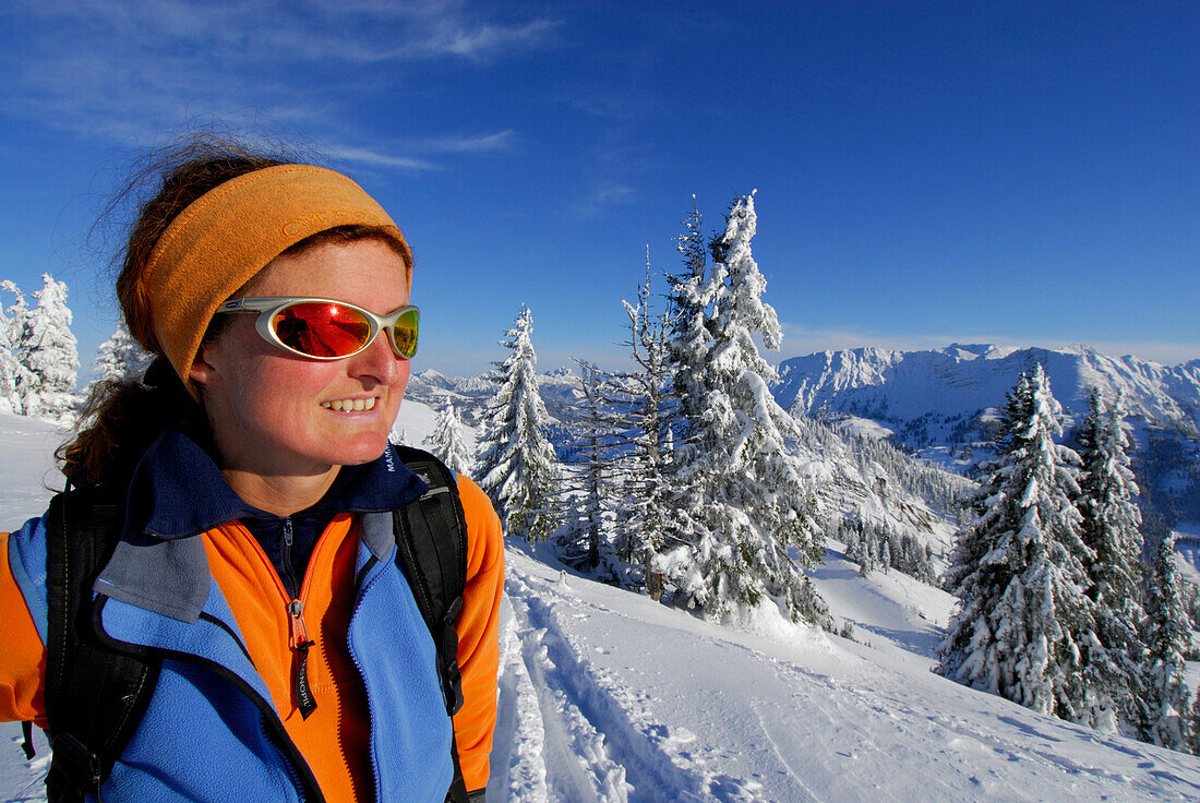 Junge Frau im Aufstieg durch tief verschneiten Winterwald zum Spieser, Allgäuer Alpen, Allgäu, Schwaben, Bayern, Deutschland