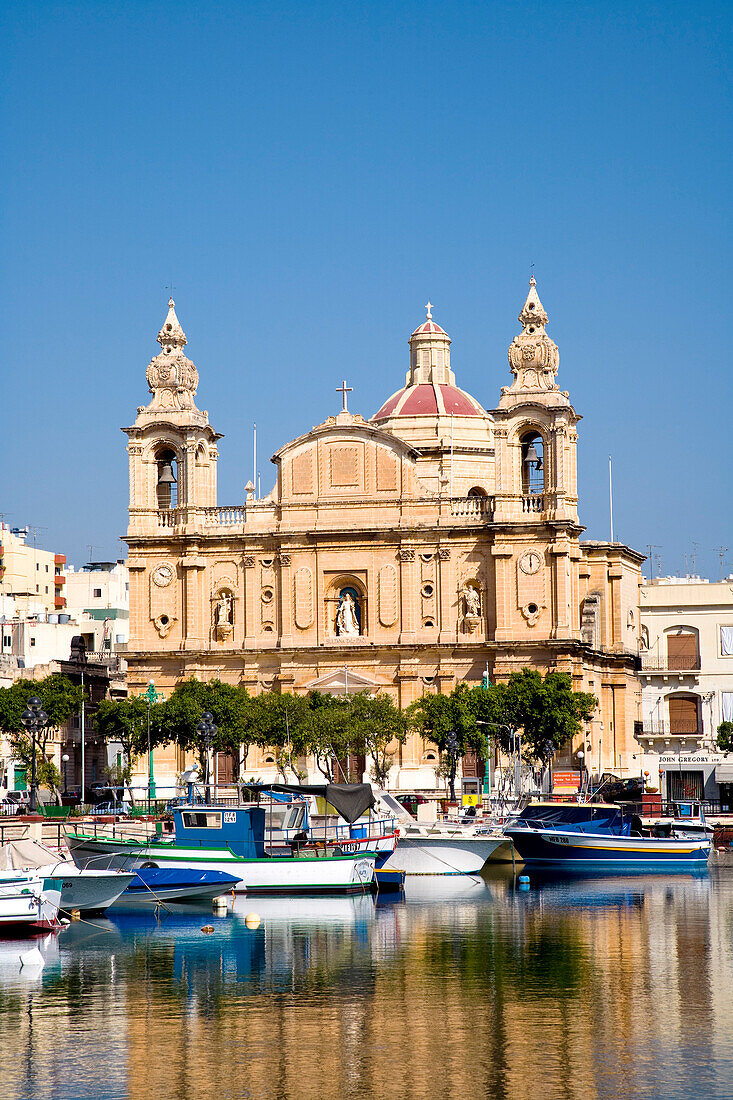 Fishing boats at harbour in front of the St. Joseph Church, Msida, Malta, Europe