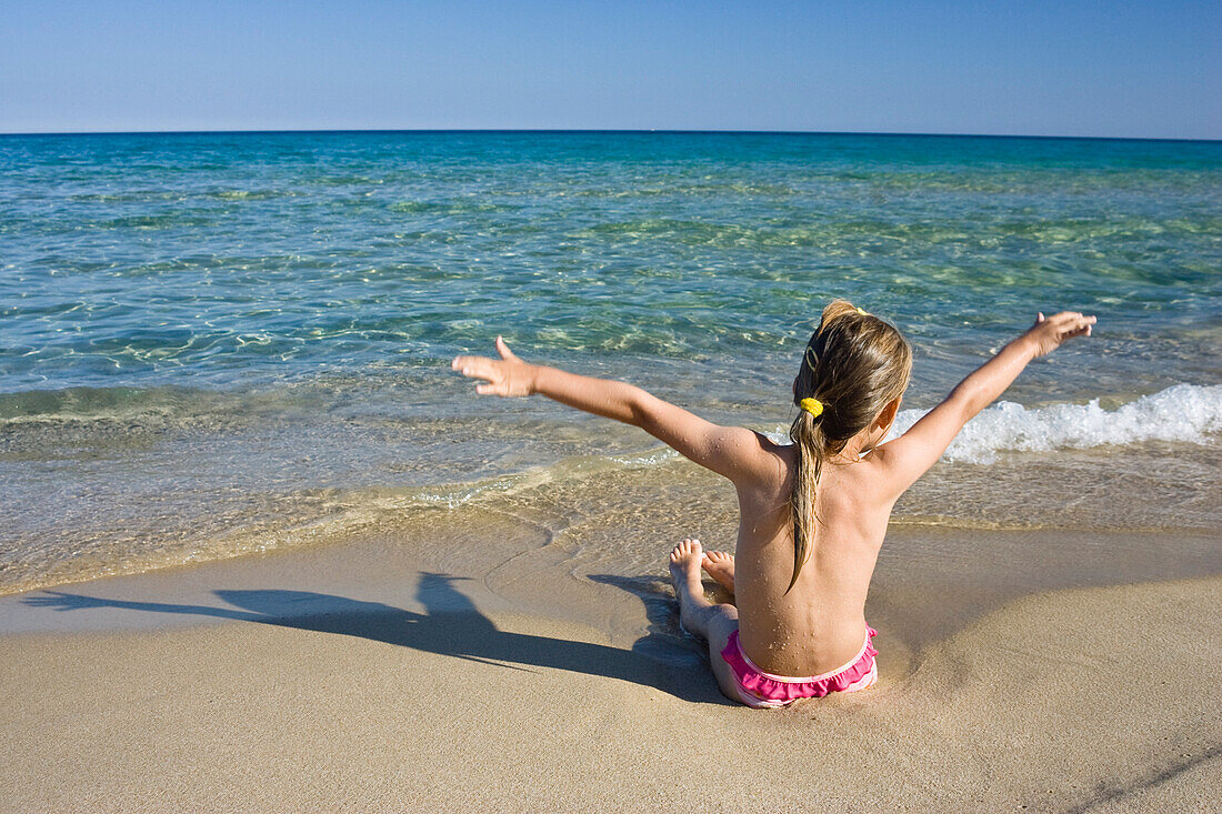 Kleines Mädchen spielt am Strand, Sardinien, Italien
