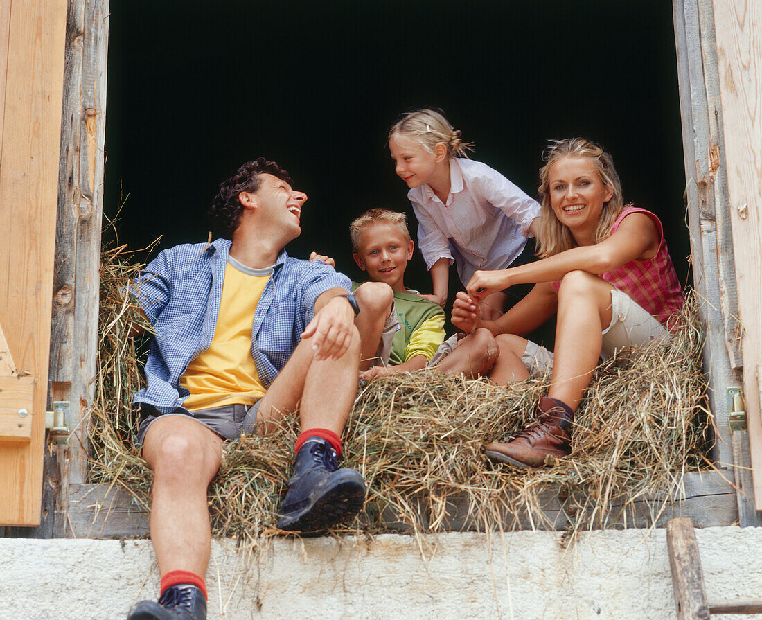 Familie sitzt im Stroh, Eng, Kleiner Ahornboden, Tirol, Österreich