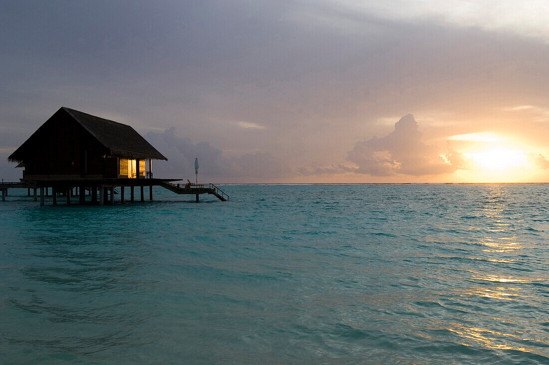 Sunset over sea with water villa, One & Only Resort Reethi Rah, Maldives